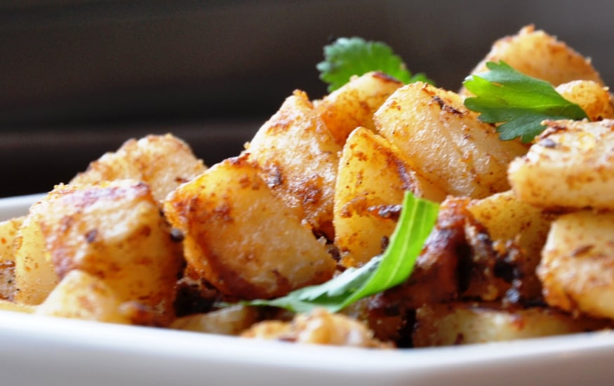 Closeup image of fried potatoes with spices and coriander, aloo masala style. 